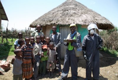IRS spray campaign team with villagers outside their home, Ethiopia