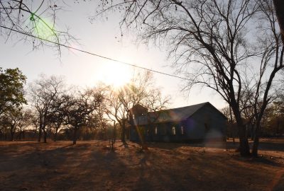 Sun shining down on a building in a rural landscape with trees in Zimbabwe