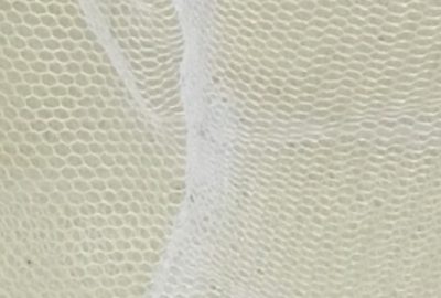 A piece of mosquito net on a beige background